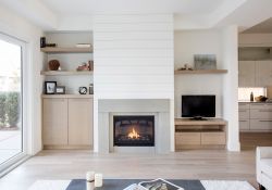 living room with a fireplace flanked with custom shelving