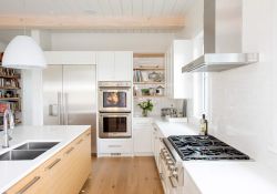 modern kitchen design with white cabinets and a wood coloured island & accents