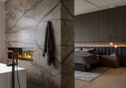 Silver Roots Slabs applied to double sided fireplace, dividing the space between bathing and resting.  Blu Bathworks tub paired with Brizo faucet and Flare Fireplace
