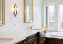 dark bathroom double vanity with gold mirrors